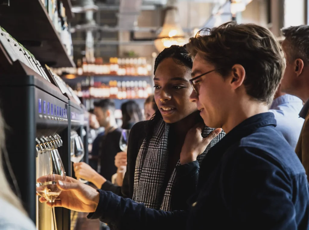 A young man and woman enjoying self serve wine